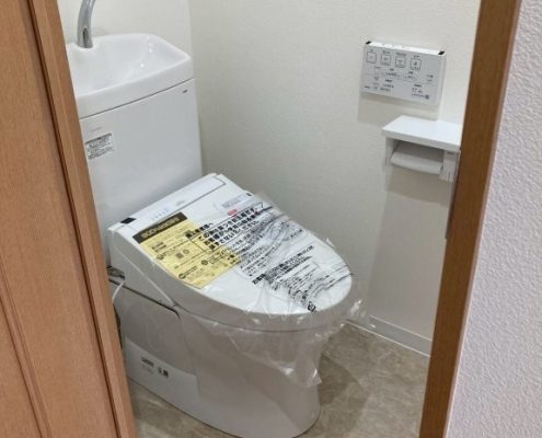 東京都大田区I様邸のトイレリフォーム後の様子。TOTOピュアレストQRとウォシュレットを新設し、白いクロス（SP-9712）と石目調クッションフロア（HM-17030）で清潔感ある空間に仕上げた施工後写真。